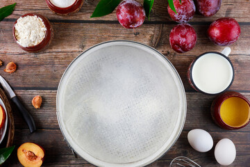Preparation dessert plum pie on wooden table.