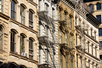 Fototapeta na wymiar Typical Soho loft building facades with fire escapes. Manhattan, New York City