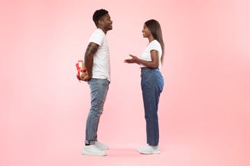 Happy black man making surprise for his woman giving box