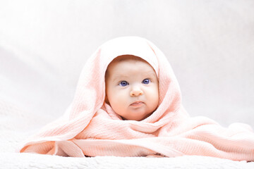 Cute baby with towelthree month old blue-eyed girl wrapped in a terry towel