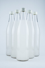 A white bottle with a soda drink on ice isolated.