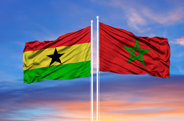 Morocco and Ghana two flags on flagpoles and blue cloudy sky
