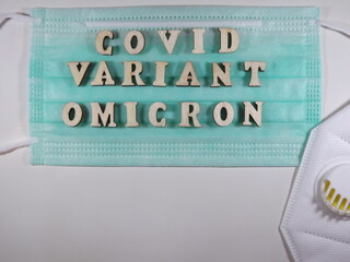 The word covid variant omicron in wooden letters on the face mask. High quality photo