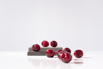 Cerezas dulces mojadas con gotas de agua sobre piedras grises y fondo claro