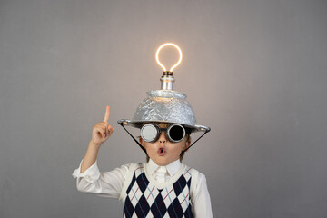 Smart child wearing funny helmet with illuminated lightbulb