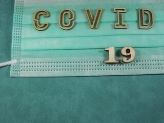 The word covid variant omicron in wooden letters on the face mask. High quality photo