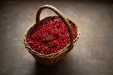 A wicker basket with red currant berries. Summer harvest. Seasonal vitamins.