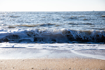 Waves crashing like bubbles that come in white from the horizontality of the winter sea,