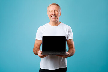Happy mature man showing black empty pc screen