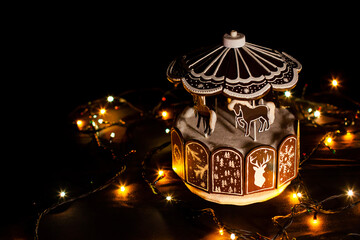 Festive carousel with horses on a black background. Beautiful bokeh. Festive lights. Screensaver. Wallpaper. For advertising