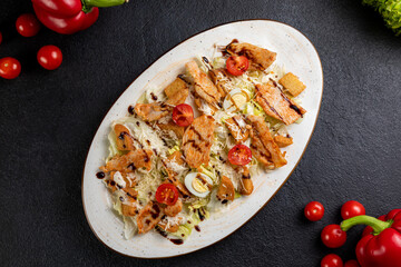 Caesar salad served on a white plate. dark background decorated with food