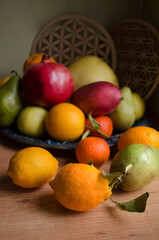 Fruits bergamot, pomegranate, lemon, pamelo, pear, tangerine, mango on a wooden background.