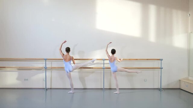 Girls young ballerinas practicing ballet positions in dance class at school. Ballet gymnastics classes. Children in sport, improving their skills to perform on stage. Gymnasts training