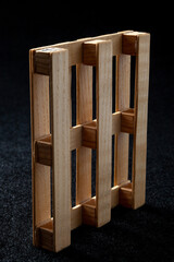 Reduced model wooden euro pallet on black felt background....
