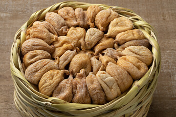 Traditional dried Turkish figs in a basket close up on wooden background 