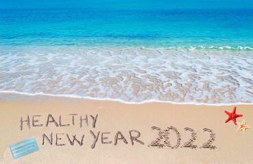 healthy new year 2022 written on the sand