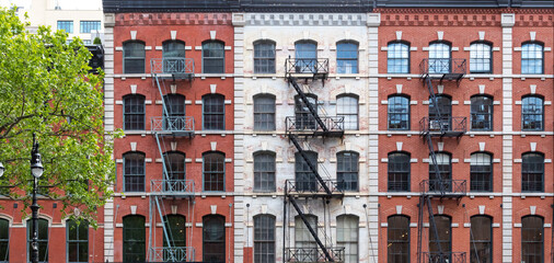 Block of old apartment buildings with windows and fire escapes in the Tribeca neighborhood of New York City - 478363526