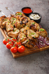 Appetizer chicken kebab with vegetables closeup on wooden board close-up. Vertical