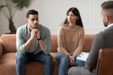 Couple talking at therapy session with professional male therapist - obrazy, fototapety, plakaty