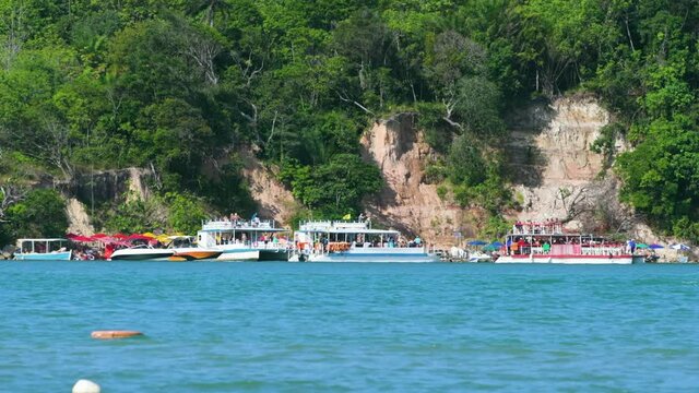 Tourist motorboats and catamarans at the Guadeloupe beach for the clay bath, tourist destination of Sirinhaem, Pernambuco state.