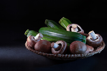 fresh vegetables on black background, zucchini and mushroom. Copy space