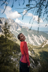 Naklejka premium Happy woman enjoying her hike in Julian Alps in Slovenia on a beautiful sunny day on a late summer day.