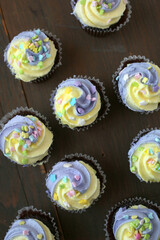 Yellow and purple easter cupcake on wooden background