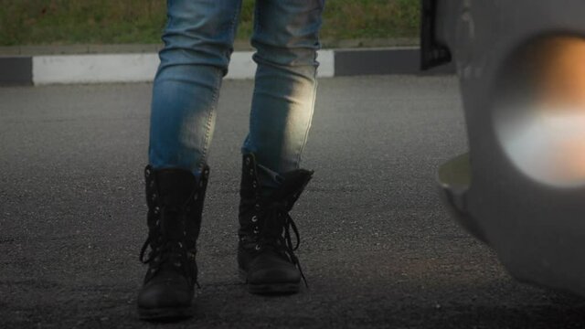 A car pulls up abruptly to a man standing on the road. Legs close-up. The concept of a traffic accident
