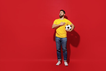 Full size body length happy young bearded man football fan in yellow t-shirt support favorite team...