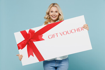 Elderly woman 50s wearing casual striped shirt hold big large gift certificate coupon voucher card...
