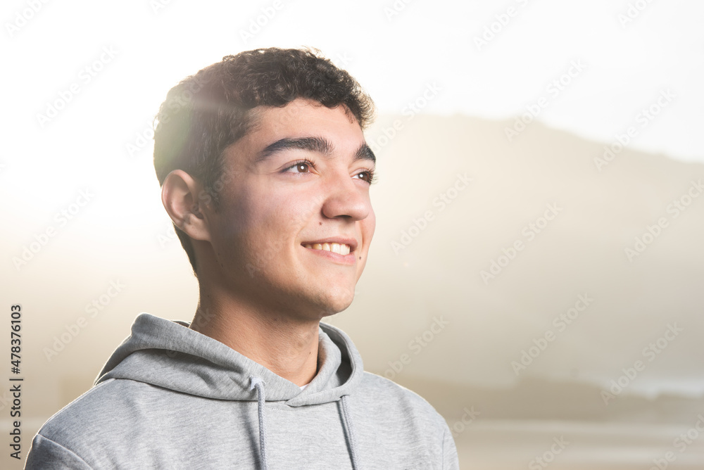 Wall mural Portrait of smiling hispanic teenager boy at sunset - Wall murals