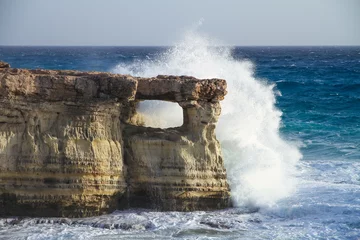 Papier Peint photo Lavable Chypre water splashing wave and hole in cliff at famous sea caves at cape greco peninsula, cyprus