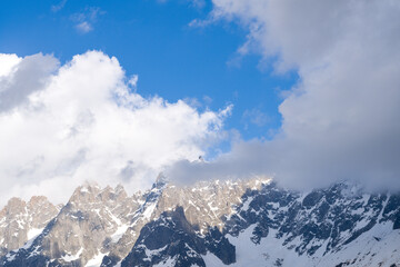 Fototapeta na wymiar Clouds surround the Aiguille de Blaitiere and the Aiguille du Plan in the Mont Blanc massif in Europe, France, the Alps, towards Chamonix, in summer, on a sunny day.