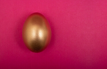 Isolated and closeup golden egg with pink background