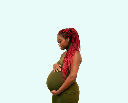 black pregnan woman wearing a green dress on a colorful background