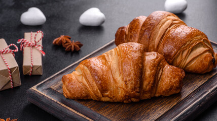Delicious fresh crispy croissants on a dark concrete background