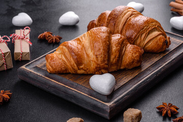 Delicious fresh crispy croissants on a dark concrete background