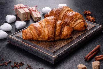 Delicious fresh crispy croissants on a dark concrete background
