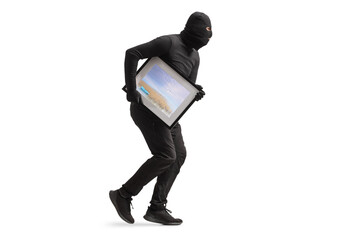 Burglar in black clothes and balaclava stealing a painting and running
