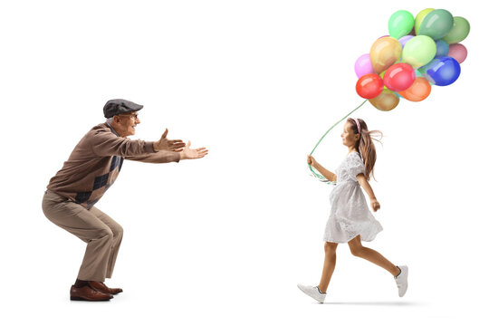 Full length profile shot of a girl with balloons running towards grandfather