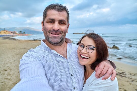 Happy mature couple taking selfie photo on smartphone.
