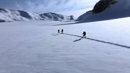 Aerial view of two person doing cross country skiing on the mountain with snow in Plaine Morte Glacier, Switzerland.