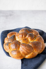 Homemade round challah with poppy seeds.