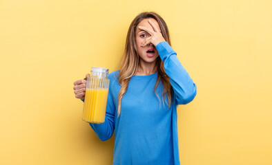 pretty woman looking shocked, scared or terrified, covering face with hand orange juice concept