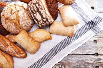 Top view of different types of bread on wooden table