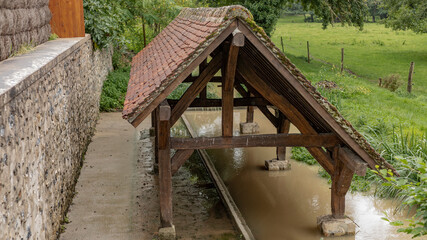Old rustic french wash house by the side of a stream