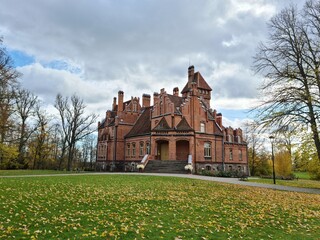 Fototapeta na wymiar Beautiful old Latvian castle Jaunmoku among trees with yellowed leaves October 16, 2021