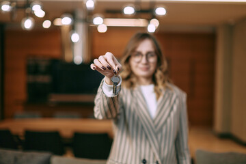 Take keys. Close up blurred portrait of female real estate owner seller broker propose to get key from new home flat