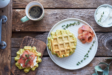 Belgian avocado waffles with salmon. Side view, wooden background. Rustic. 