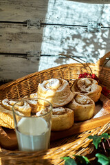 Rose cinnamon rolls. Brioche. Top view, wooden background, cocoa, yeast buns, basket, milk. 